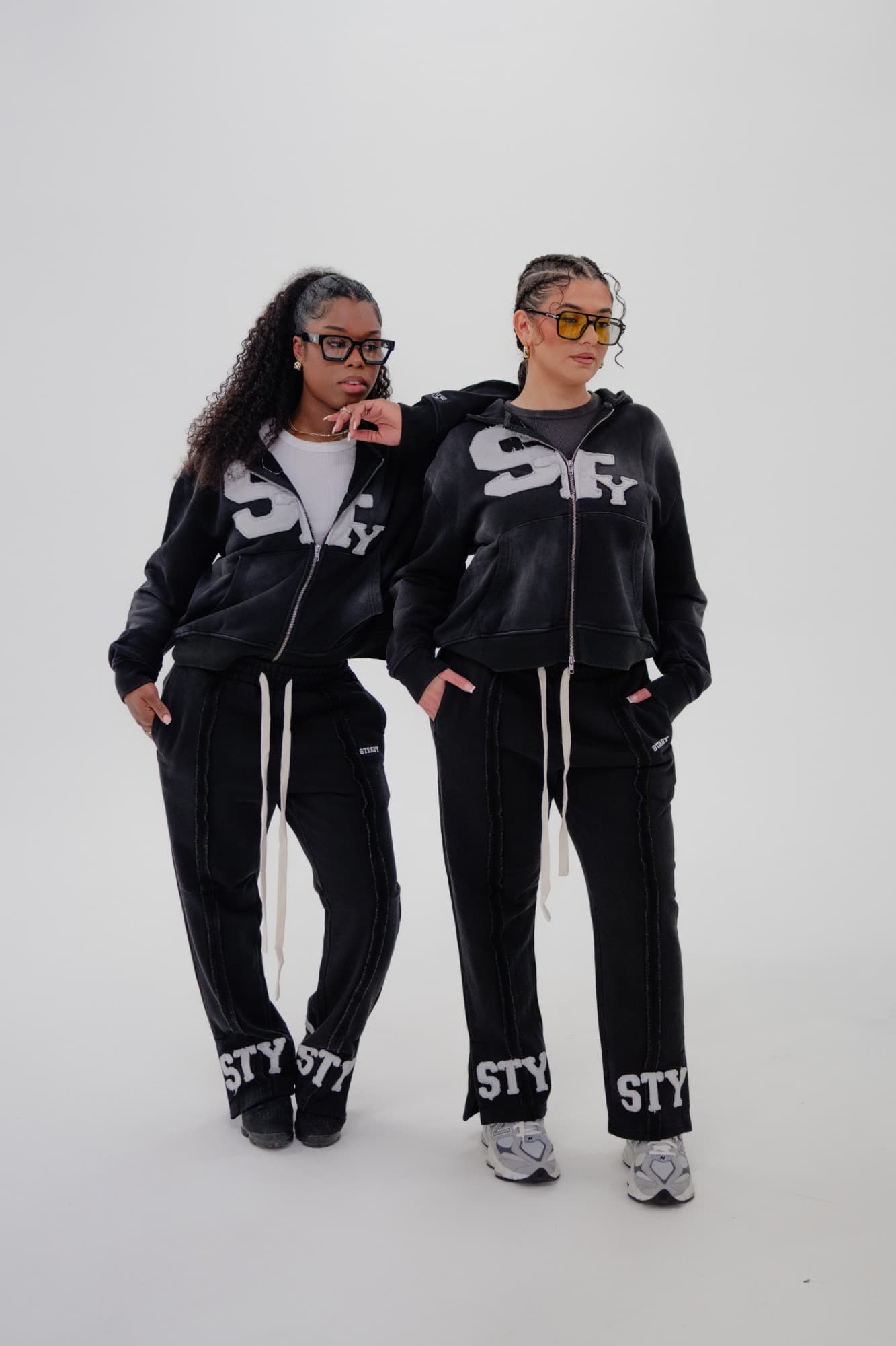 Steady lookbook: two models in black STY zip hoodies and joggers with white STY lettering